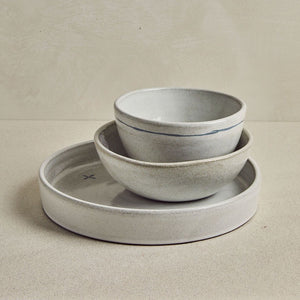 Trio de vaisselle de céramique grise, sur fond beige